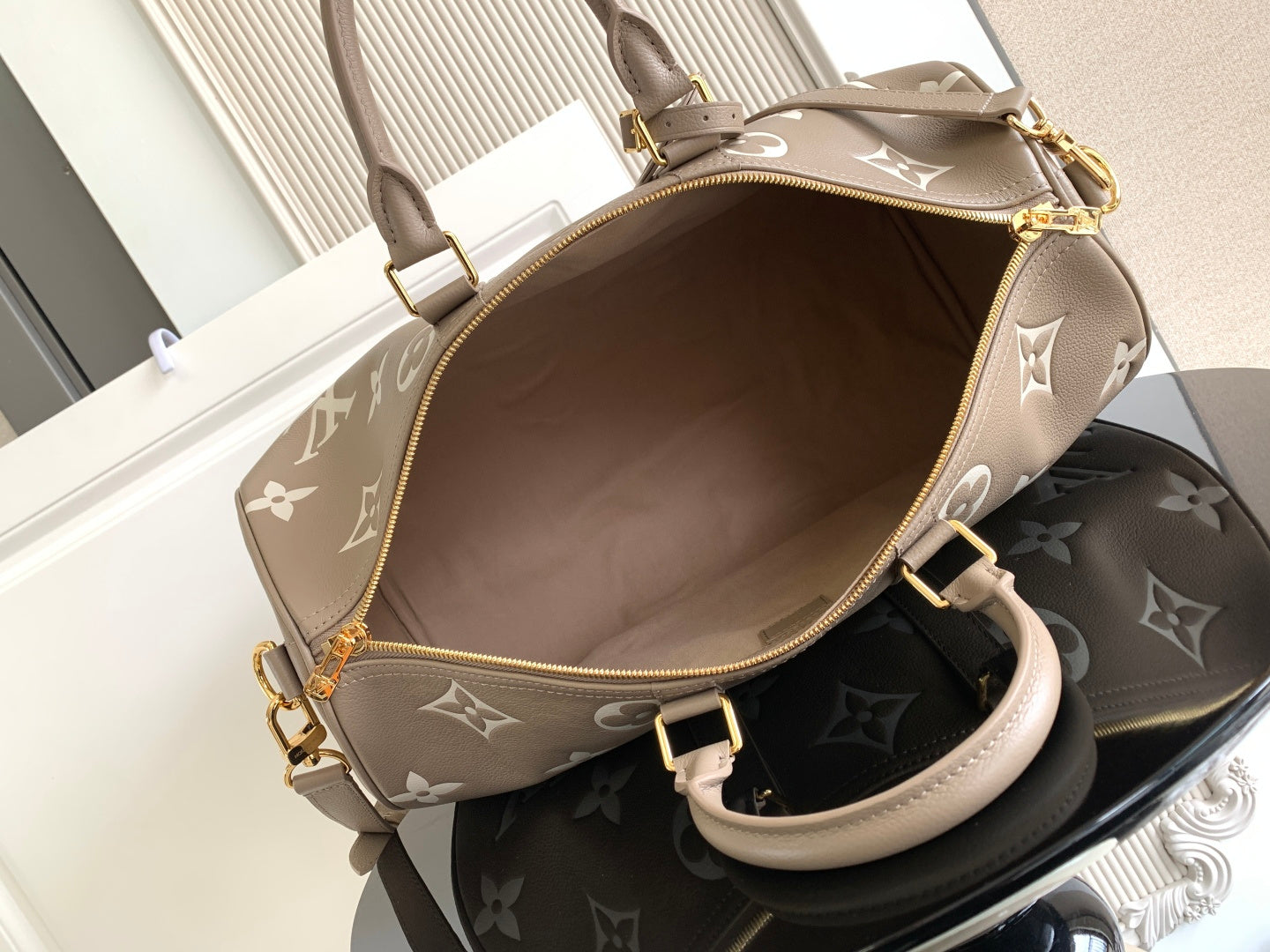 Louis Vuitton bag top view: taupe exterior with monogram pattern and gold zipper