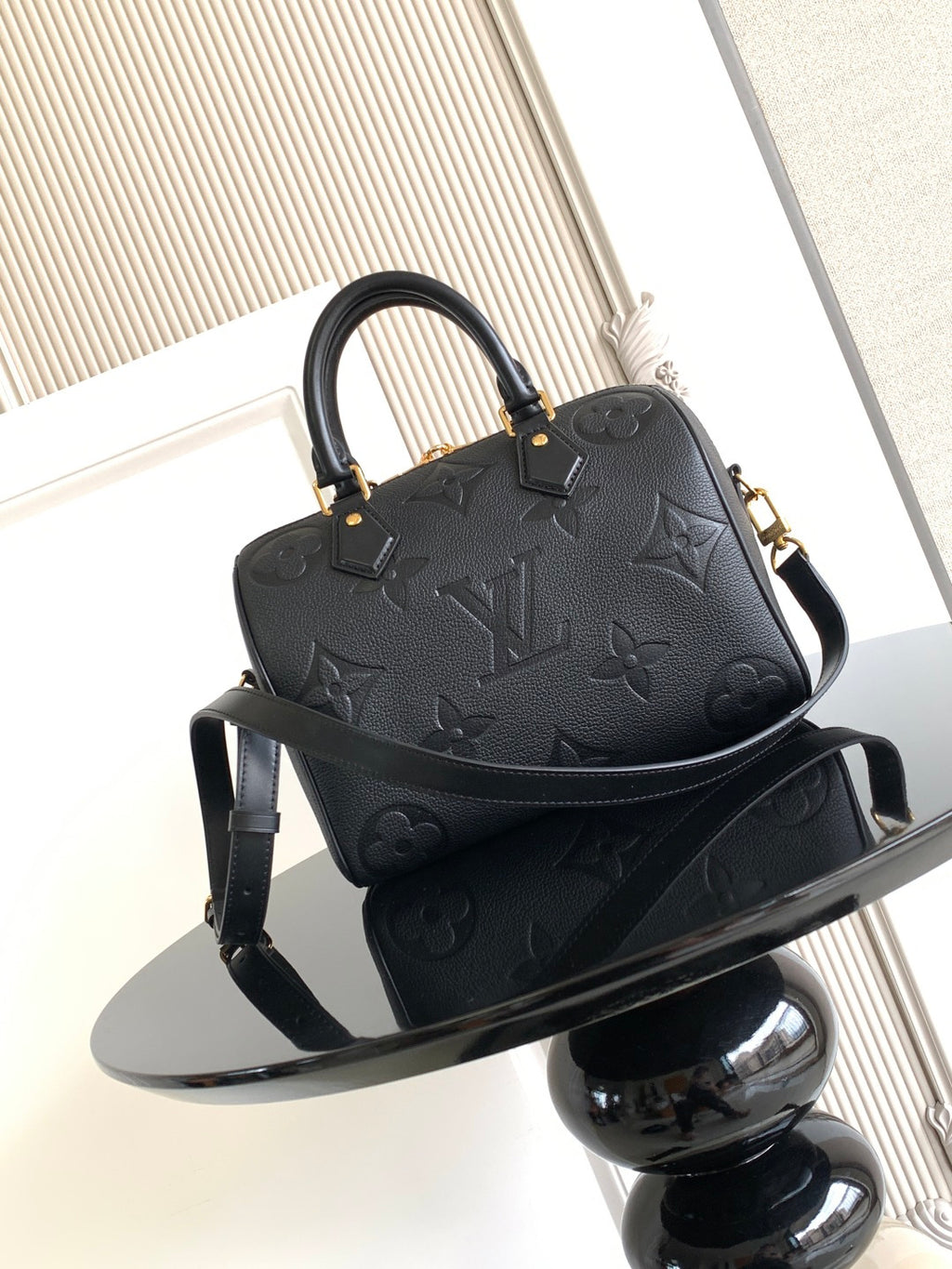 Louis Vuitton monogram handbag, dark color, shown from front with shoulder strap