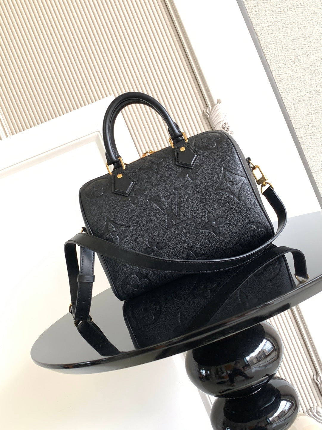 Louis Vuitton monogram handbag, dark color, shown from front with shoulder strap