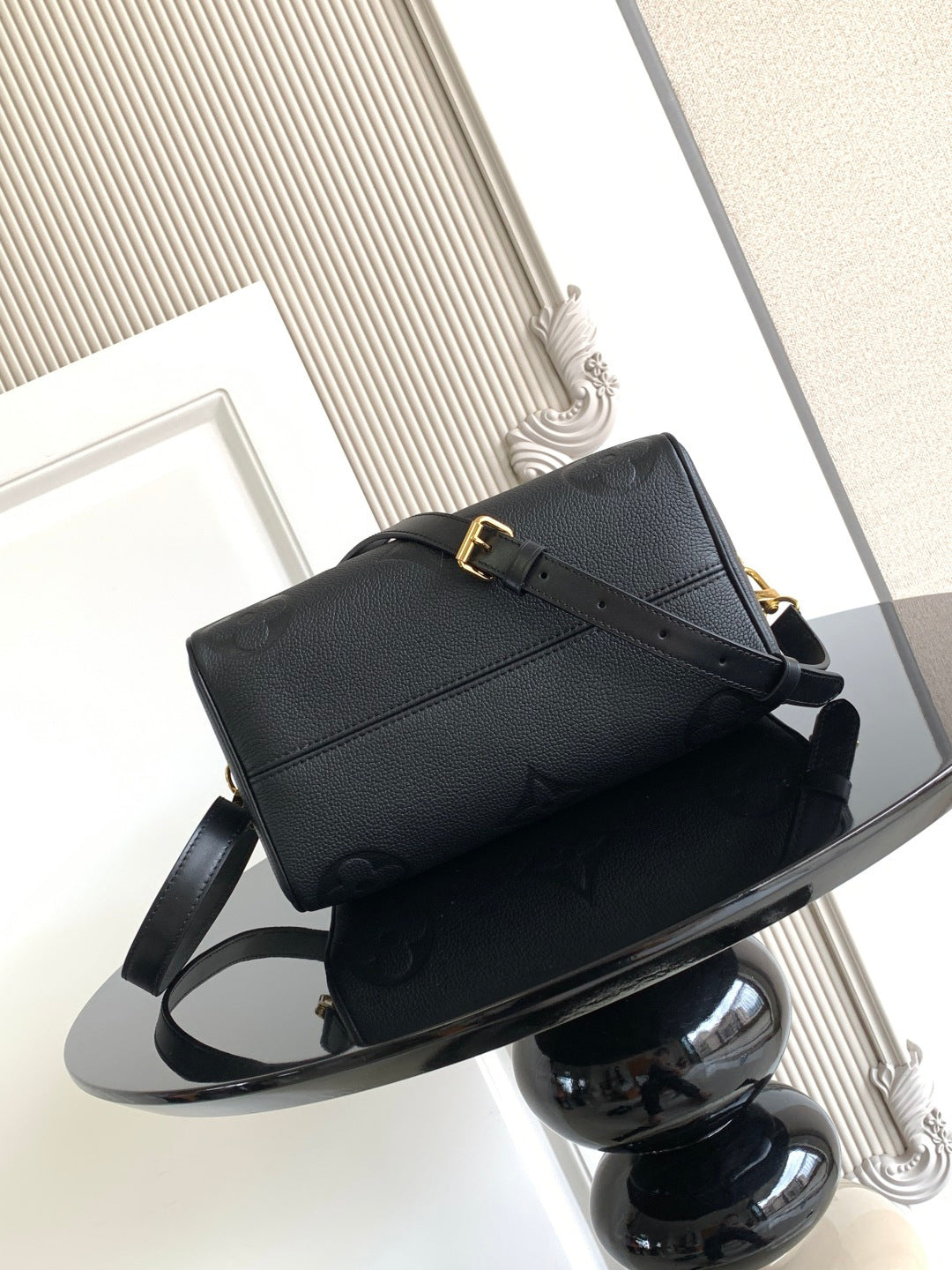 Louis Vuitton structured handbag in dark color with top handle and crossbody strap