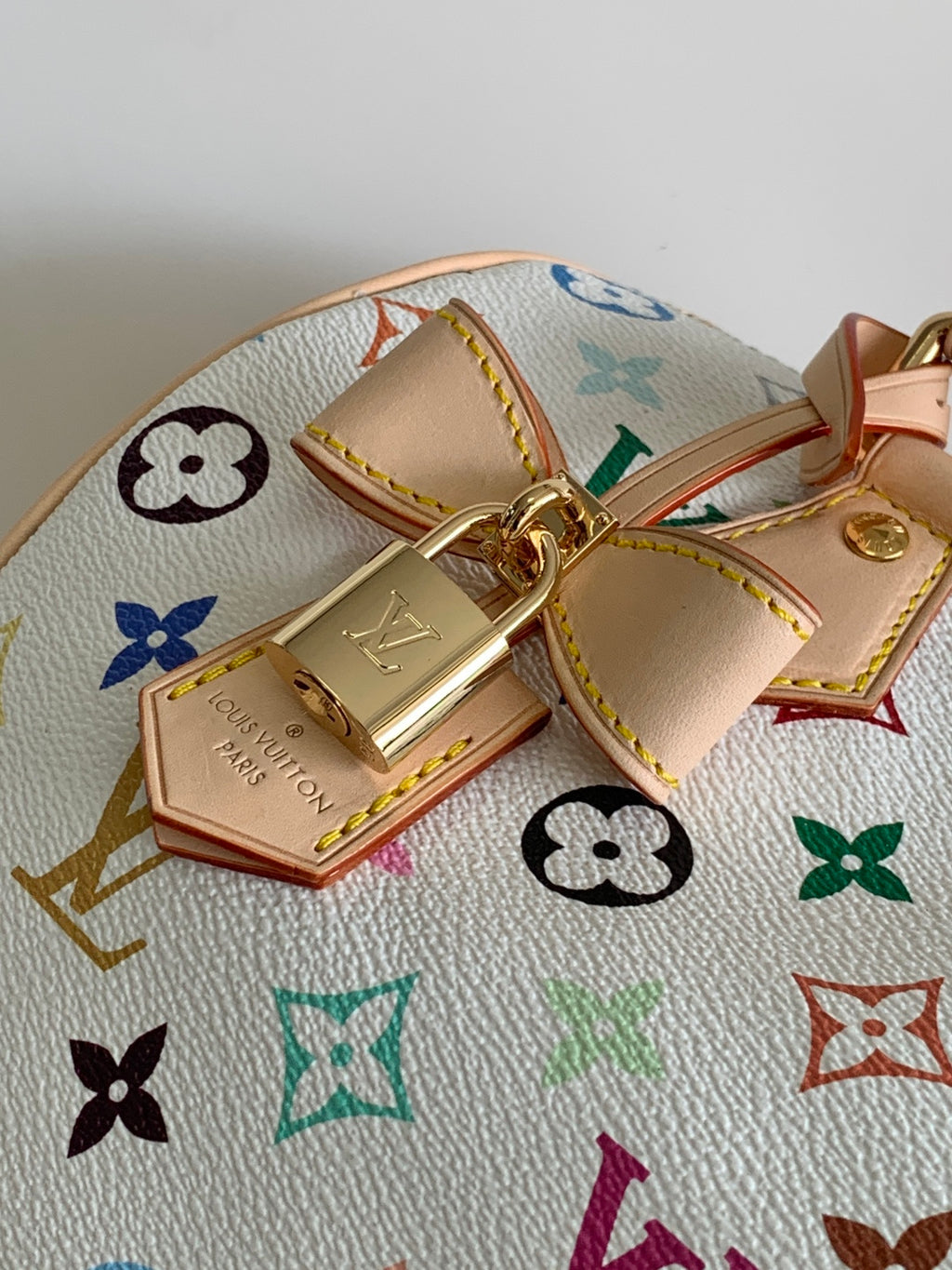 Louis Vuitton monogram handbag close-up of tan tab charm and gold clasp