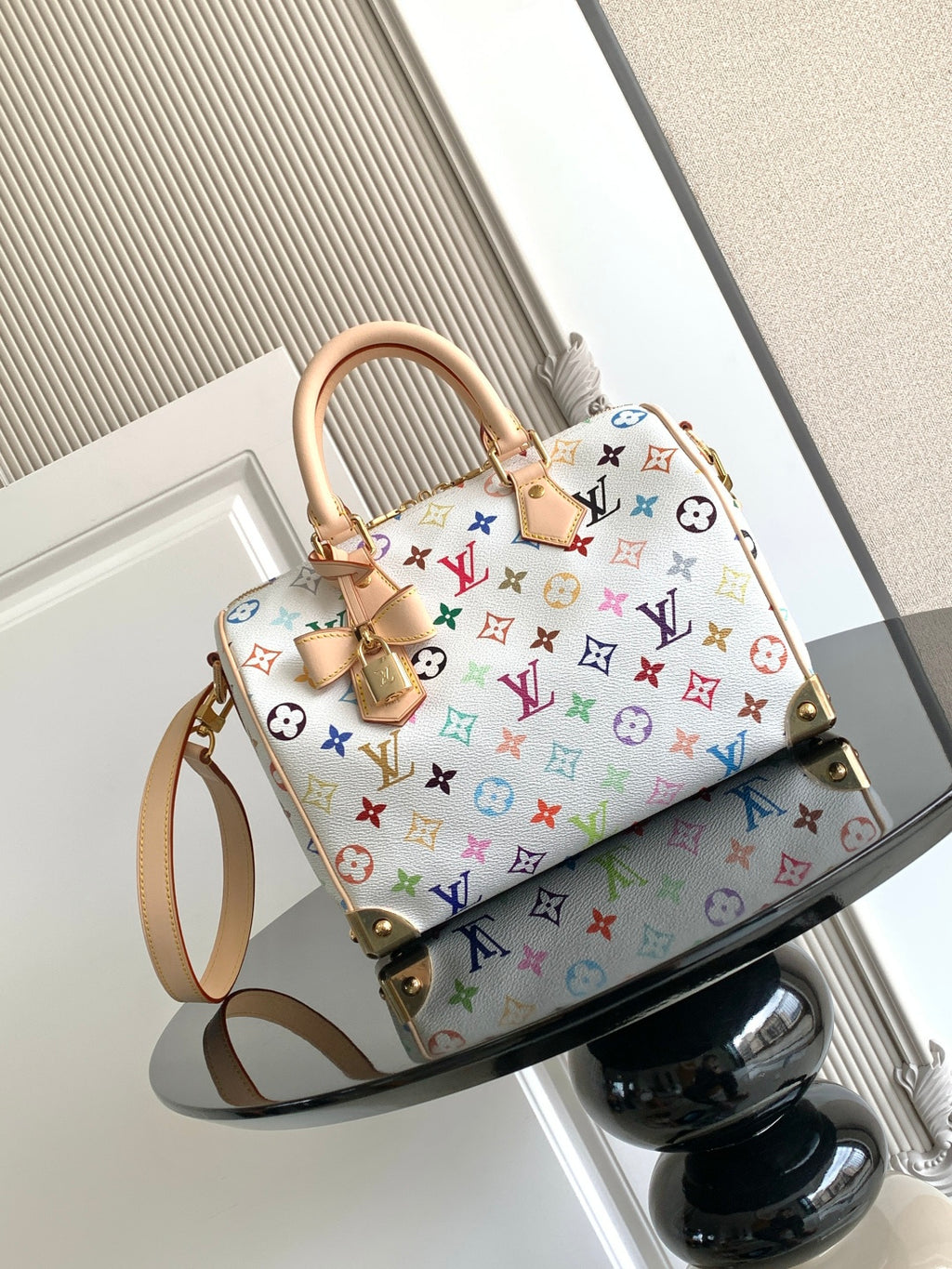 Louis Vuitton monogram handbag with multicolor pattern and tan top handles