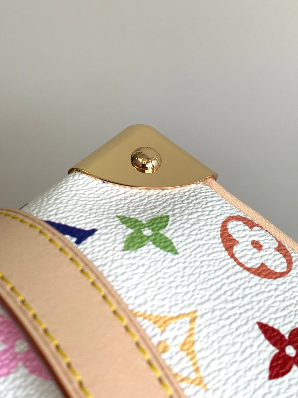 Louis Vuitton monogram handbag close-up of gold top button on multicolor canvas