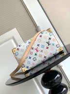 Louis Vuitton monogram handbag with multicolor print, tan strap, and gold studs