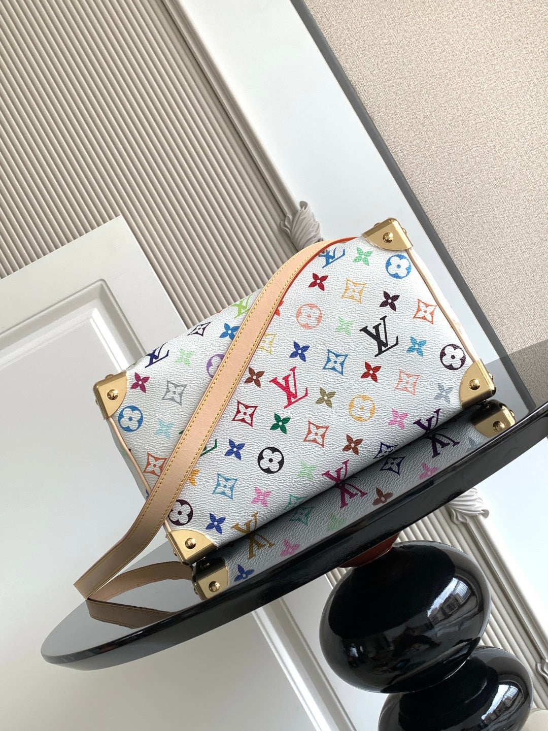 Louis Vuitton monogram handbag with multicolor print, tan strap, and gold studs