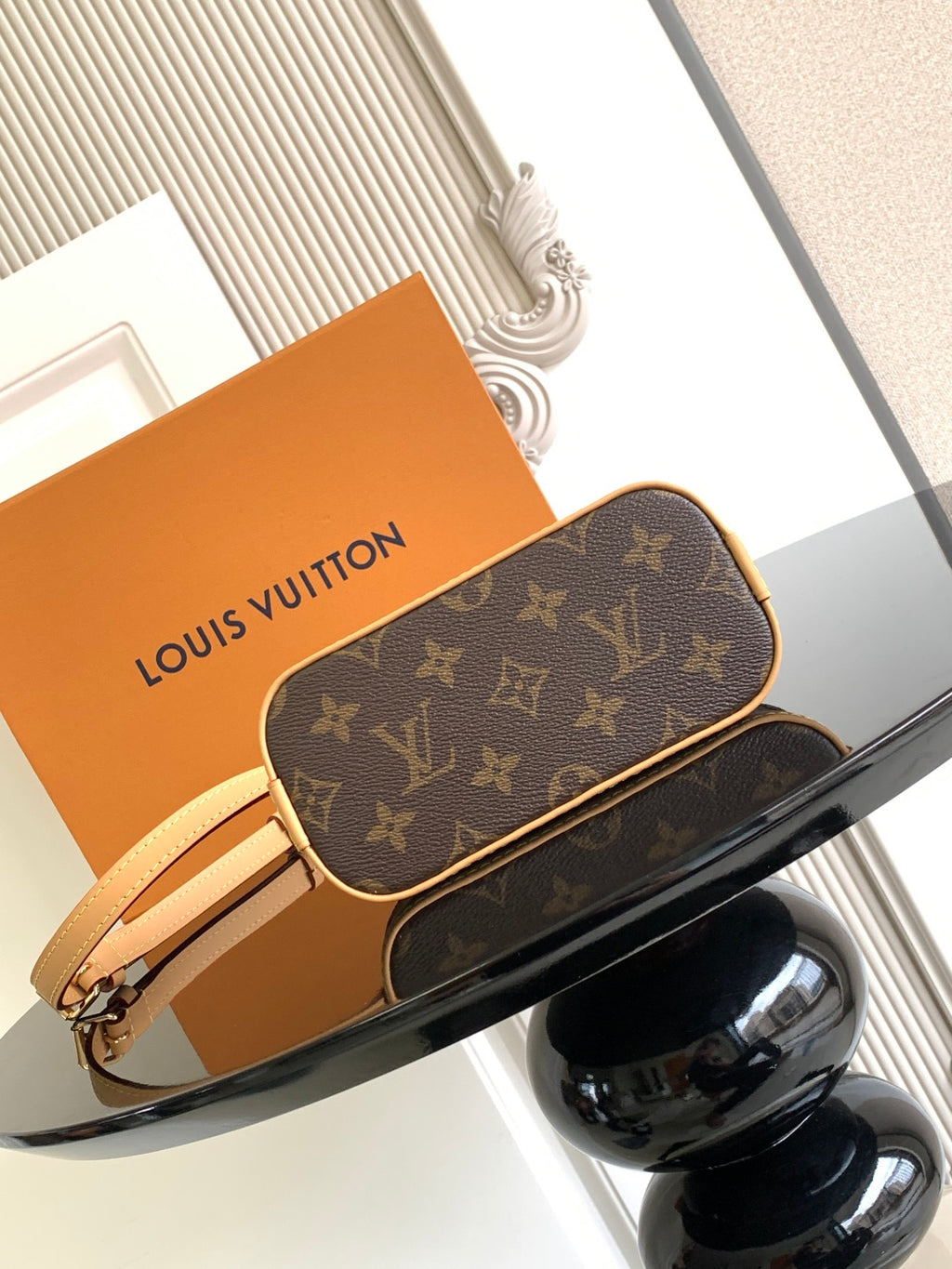 Louis Vuitton monogram crossbody bag with zipper top and tan wrist strap