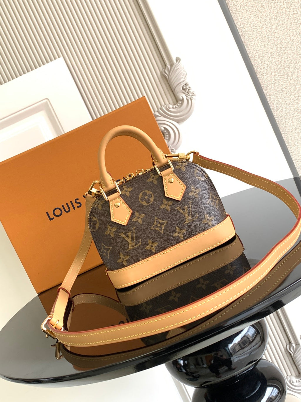 Louis Vuitton monogram mini handbag with tan strap and front plaque hardware