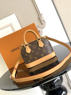Louis Vuitton monogram mini handbag with tan strap and front plaque hardware
