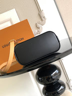 Louis Vuitton crossbody bag with black leather body and curved flap top