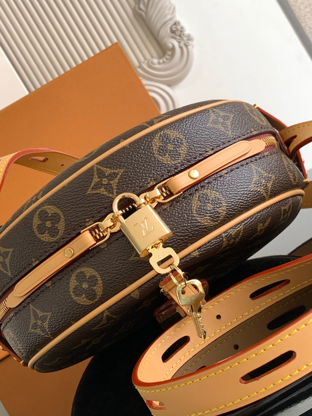 Louis Vuitton monogram bag with gold hardware and tan strap attachment