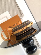 Louis Vuitton monogram crossbody bag with tan shoulder strap and gold buckle