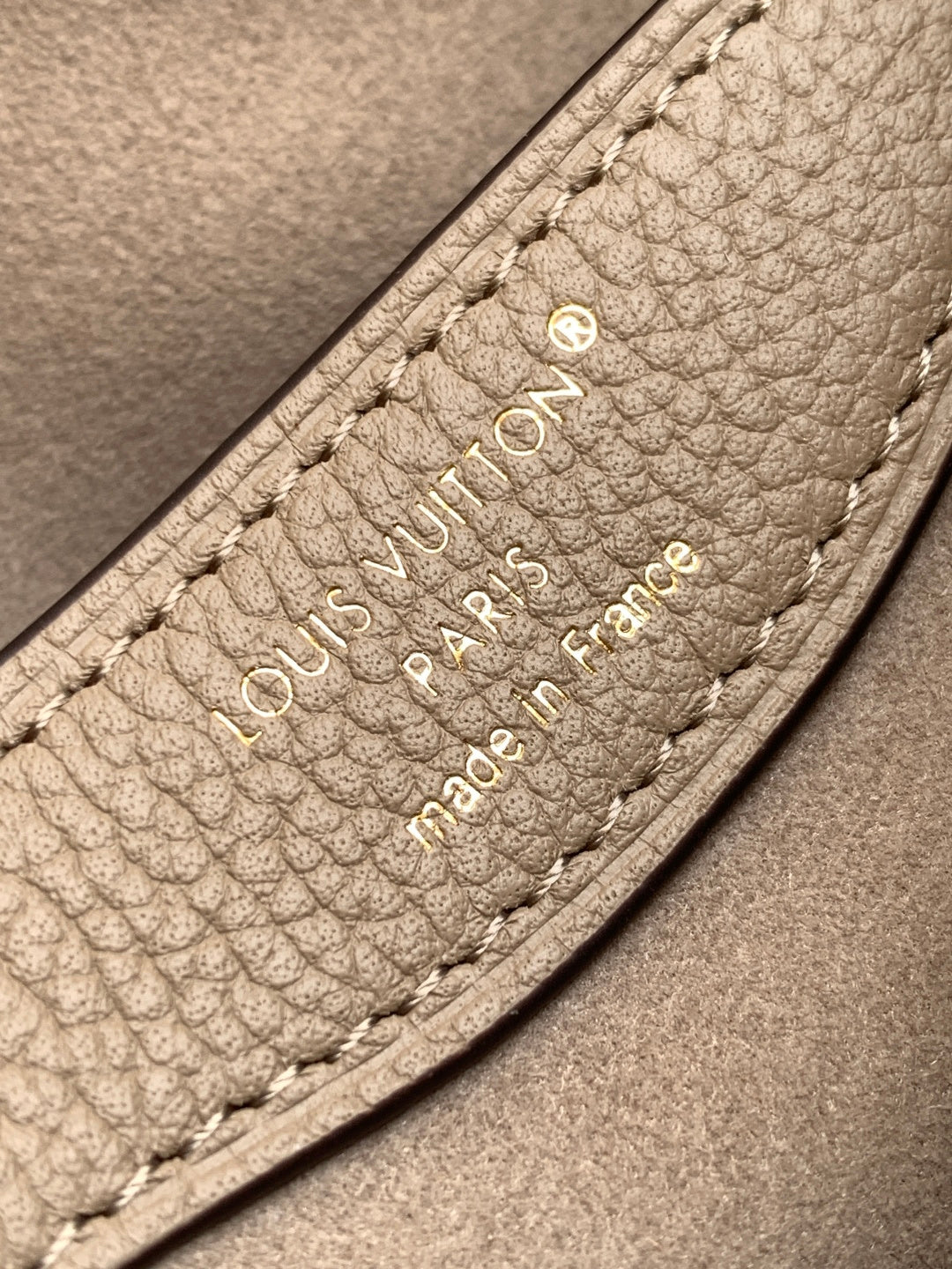 Louis Vuitton monogram bag interior label with embossed logo and stitching