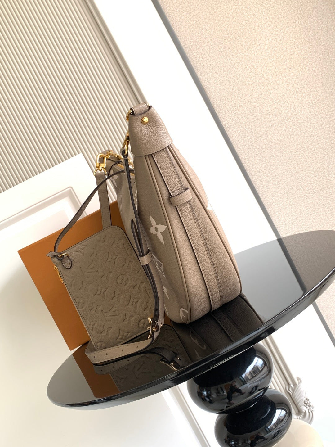 Monogram shoulder bag with taupe leather, gold hardware, and detachable strap charm.