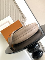 Taupe crossbody bag with structured shape, gold-toned chain strap, and top zip closure.