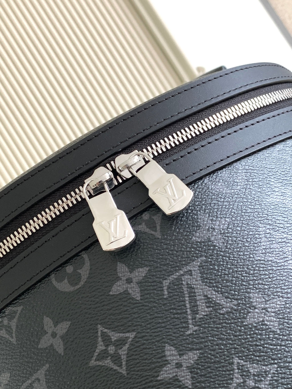 Louis Vuitton monogram backpack zipper with black leather trim close-up