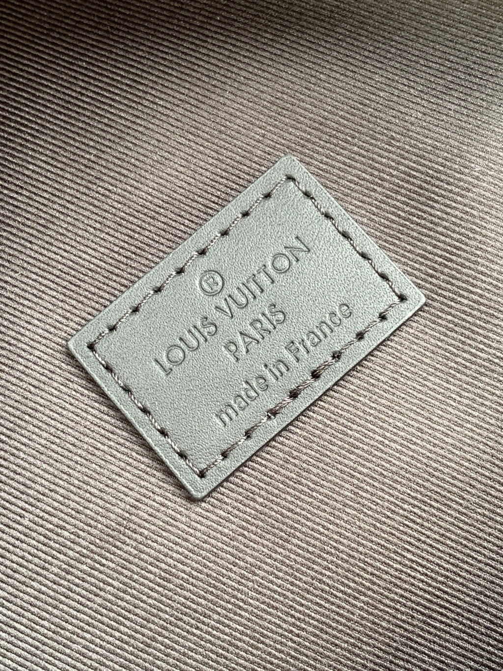 Louis Vuitton leather label with stitched border on checkered bag