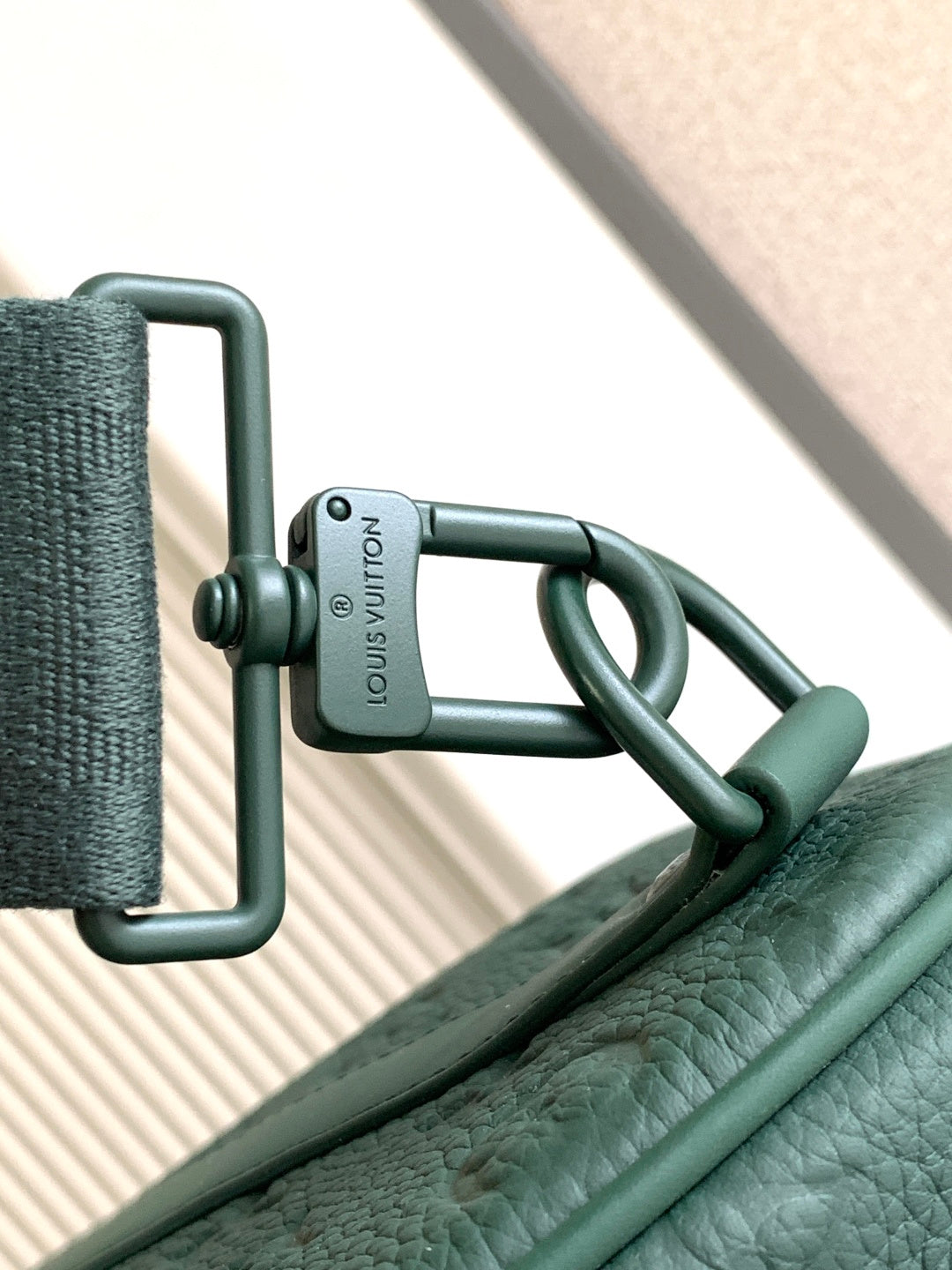 Louis Vuitton green strap with clip and Louis Vuitton label on duffel bag
