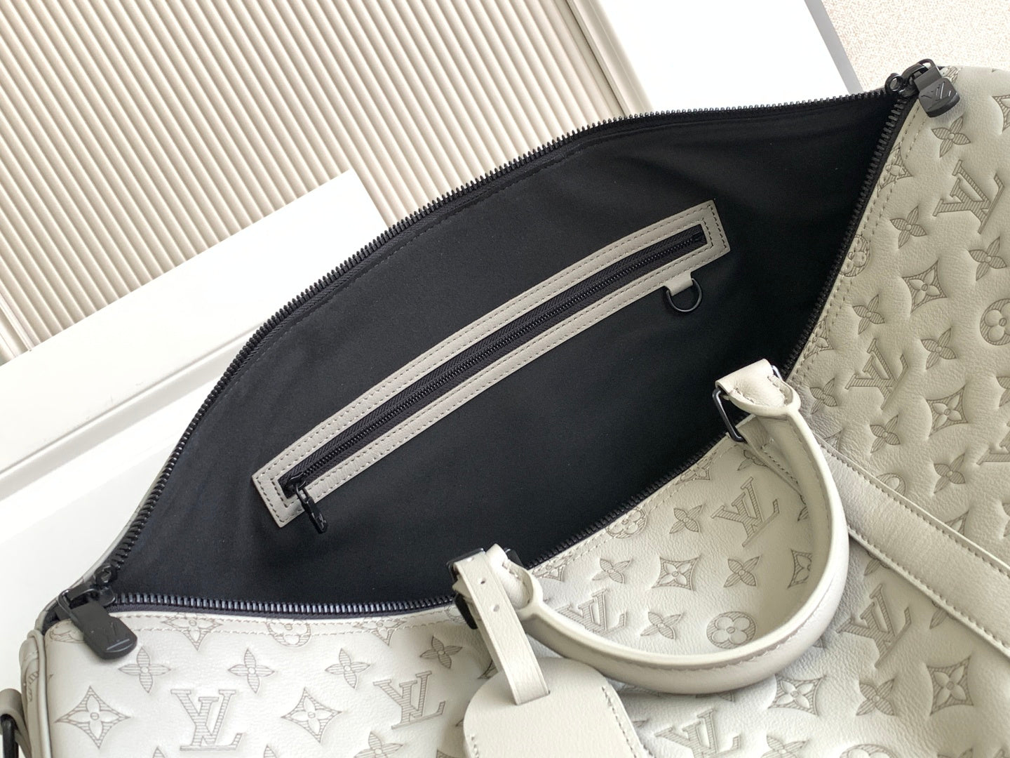 Monogram duffel bag interior with black zip pocket and light gray leather trim