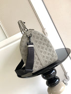 Monogram duffel bag in light gray with rolled top handles and navy strap