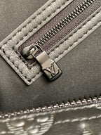 Louis Vuitton bag zipper pull and stitching detail with embossed leather and metal tab