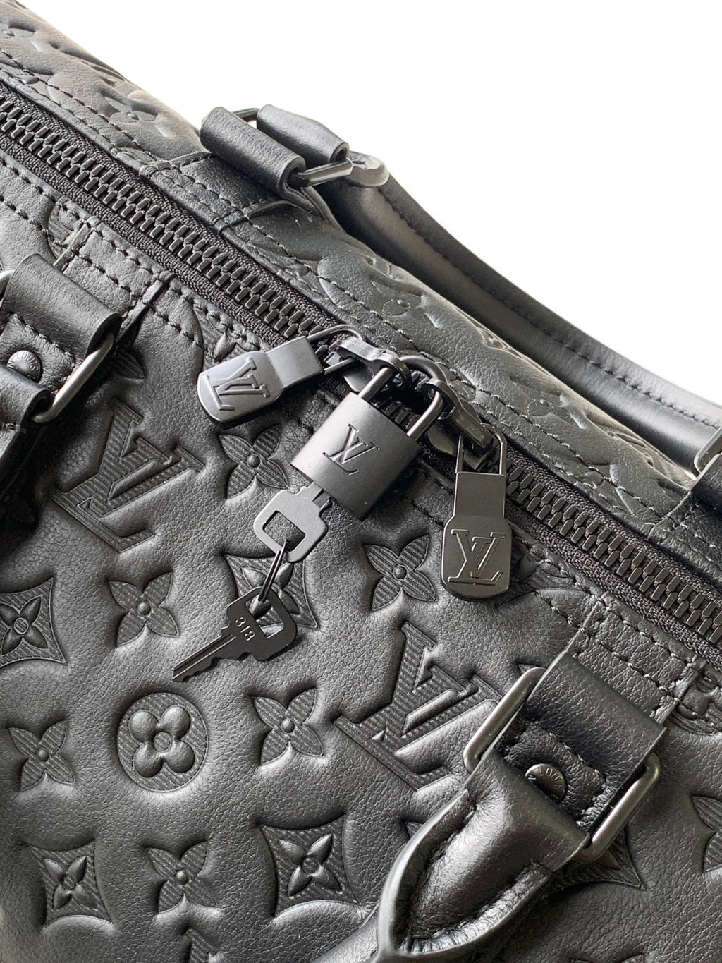 Louis Vuitton bag zipper and hardware detail with embossed monogram leather trim
