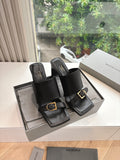 Black heeled slide sandals with square straps and gold-tone buckle detail