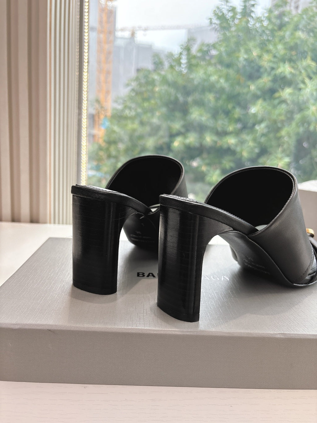 Black heeled slide sandals with chunky block heels and gold-tone buckle strap