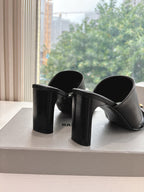 Black heeled slide sandals with chunky block heels and gold-tone buckle strap