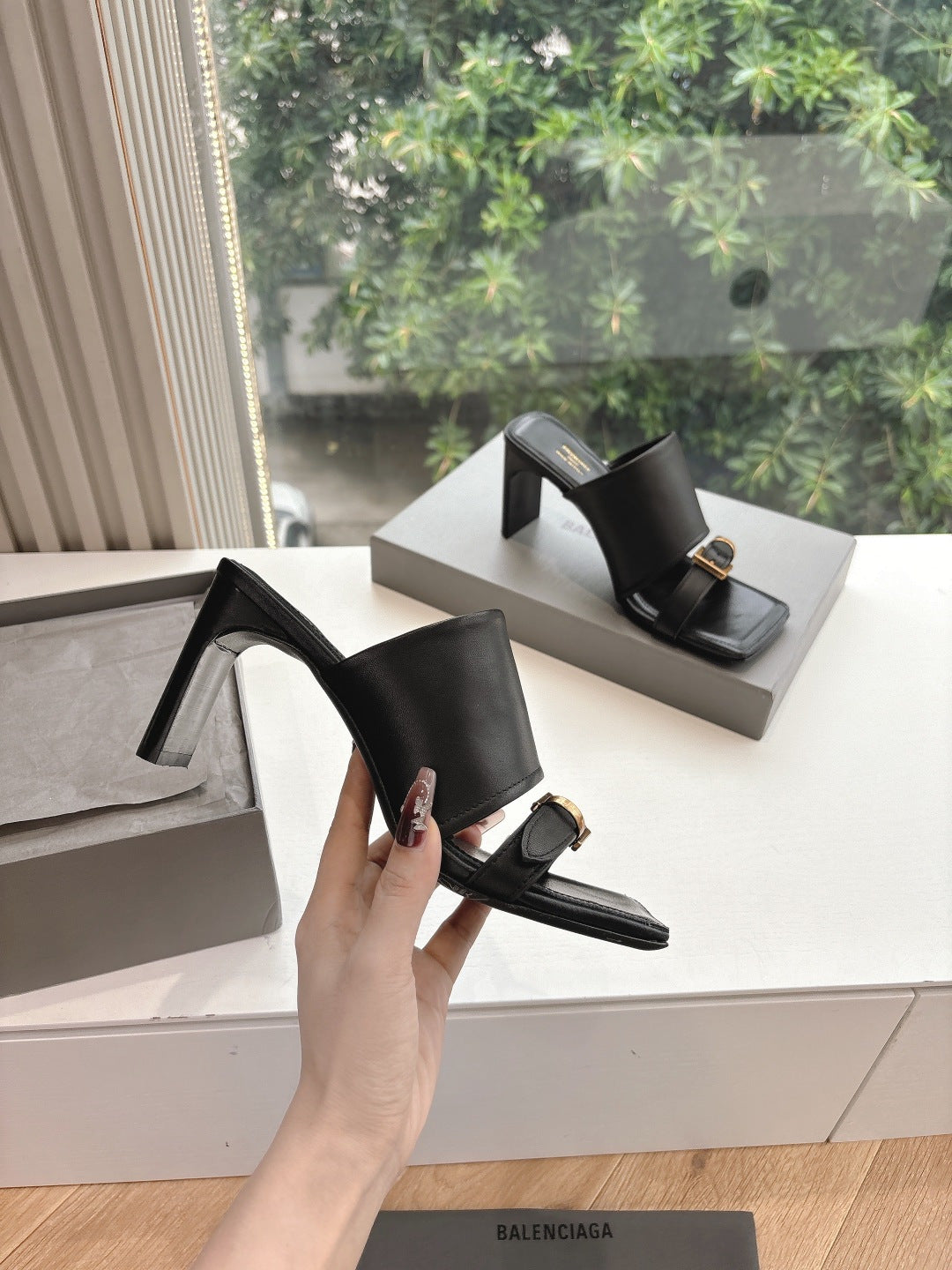 Black heeled slide sandals, open-back design with gold-tone buckle strap