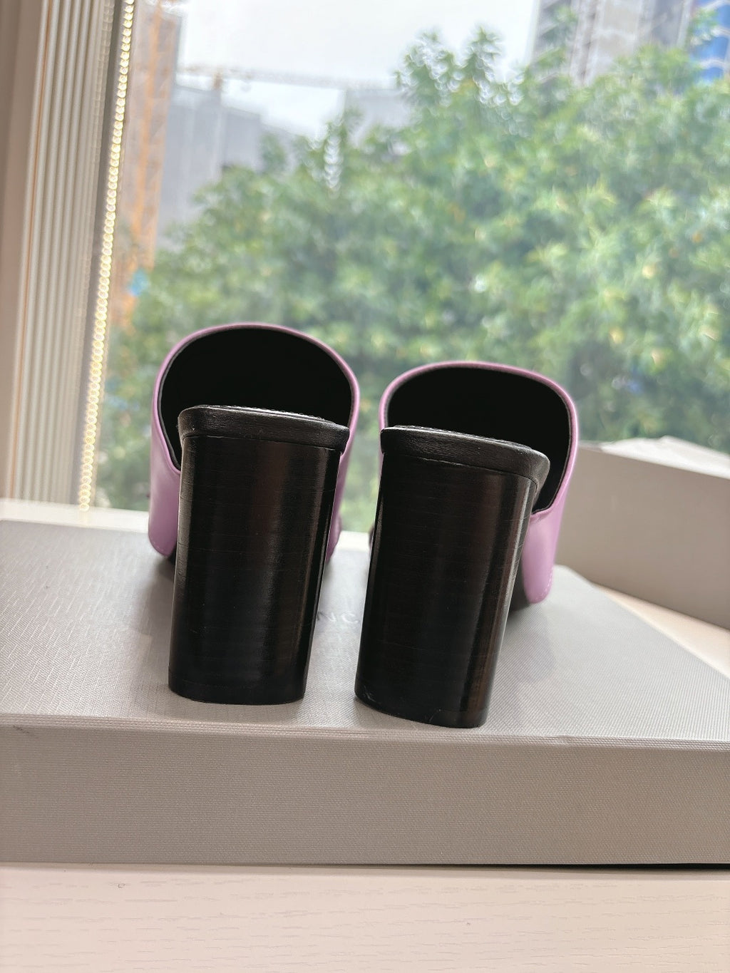 Back view of pink slide sandals with black block heels and open top