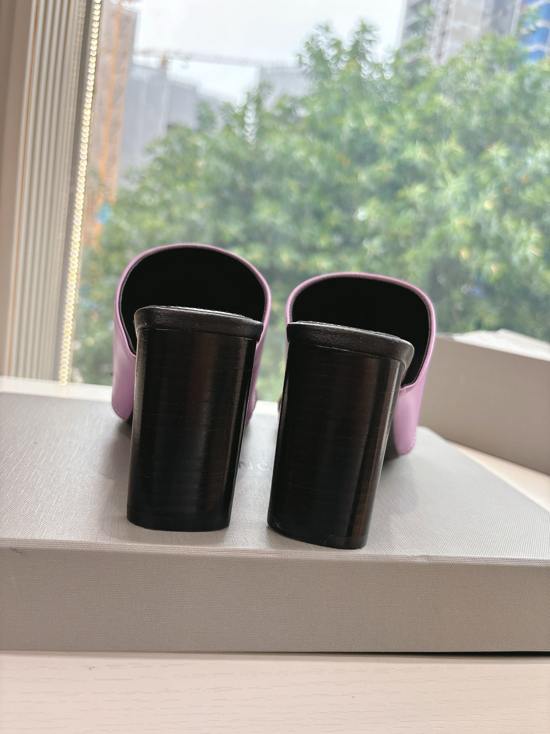 Back view of pink slide sandals with black block heels and open top