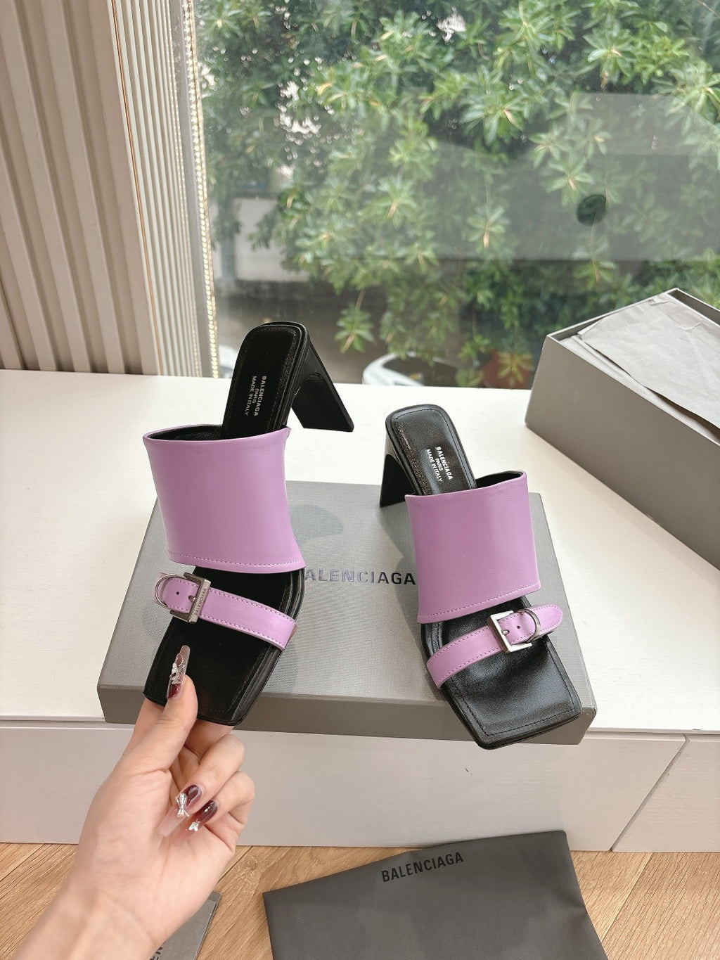 Pink mule sandals on box, black footbed with square buckle strap detail