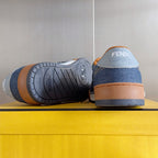 Fendi denim sneaker outsole with textured tread, tan heel, blue upper.