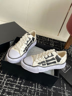 White lace-up sneakers with black side graphic and thick white platform sole