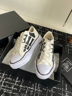 White lace-up sneakers with black side graphic and cushioned white platform sole