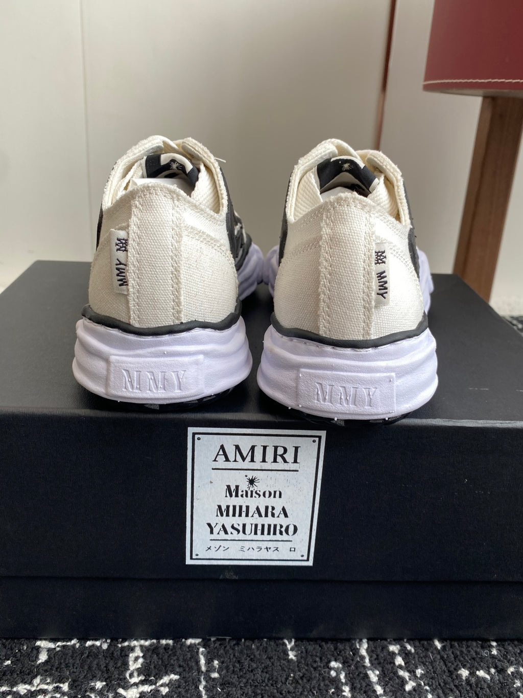 White sneakers heel view with black side logo and cushioned sole