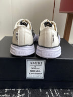 White sneakers heel view with black side logo and cushioned sole