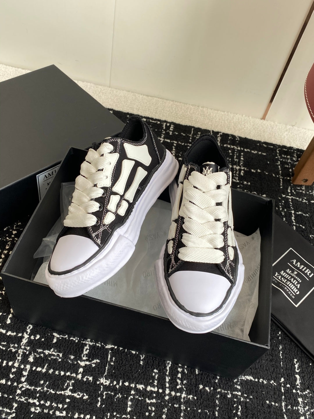 Black and white low-top sneakers with white laces and patterned side trim