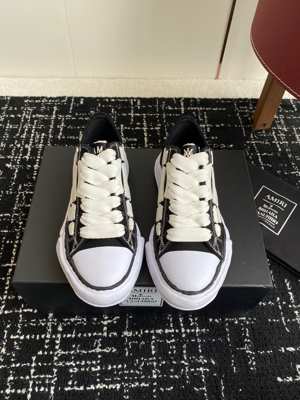 Black and white low-top sneakers with white laces and textured side panels