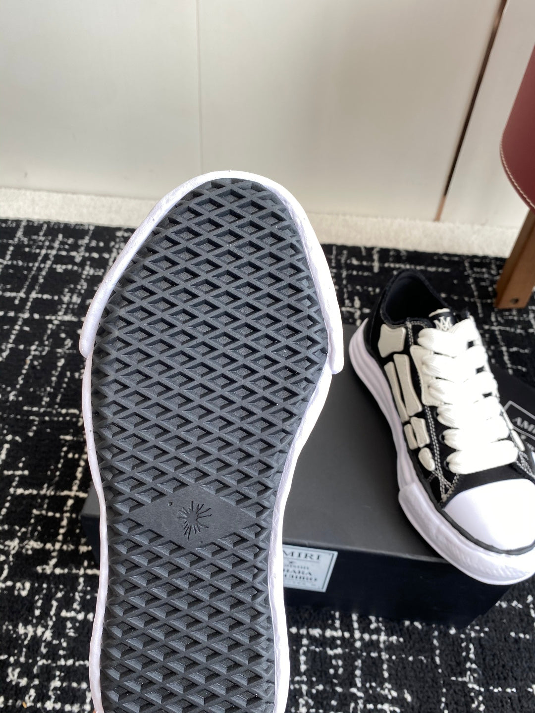 Black-and-white sneaker outsole with grid tread, toe pointing up
