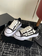 Pair of black and white low-top sneakers on box, white lace-up front