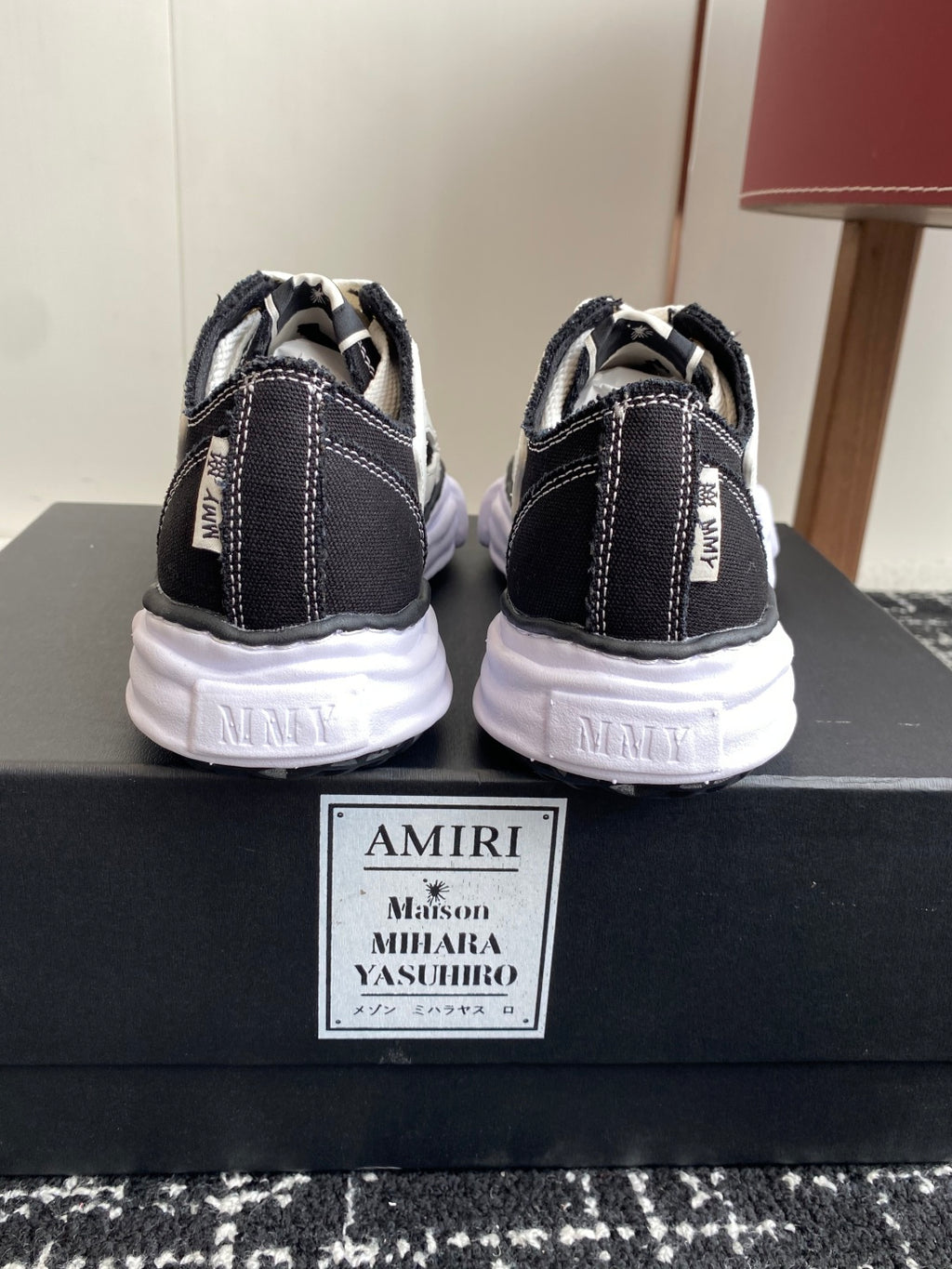 Back view of black and white sneakers with white laces and cushioned heel