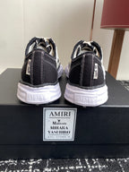 Back view of black and white sneakers with white laces and cushioned heel