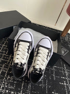 Black and white sneakers with white laces, rounded toe, lace-up detail