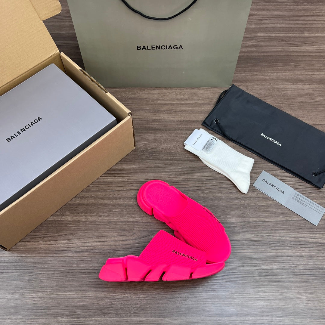 Bright pink Balenciaga slide sandals, side view with strap cutouts and textured sole