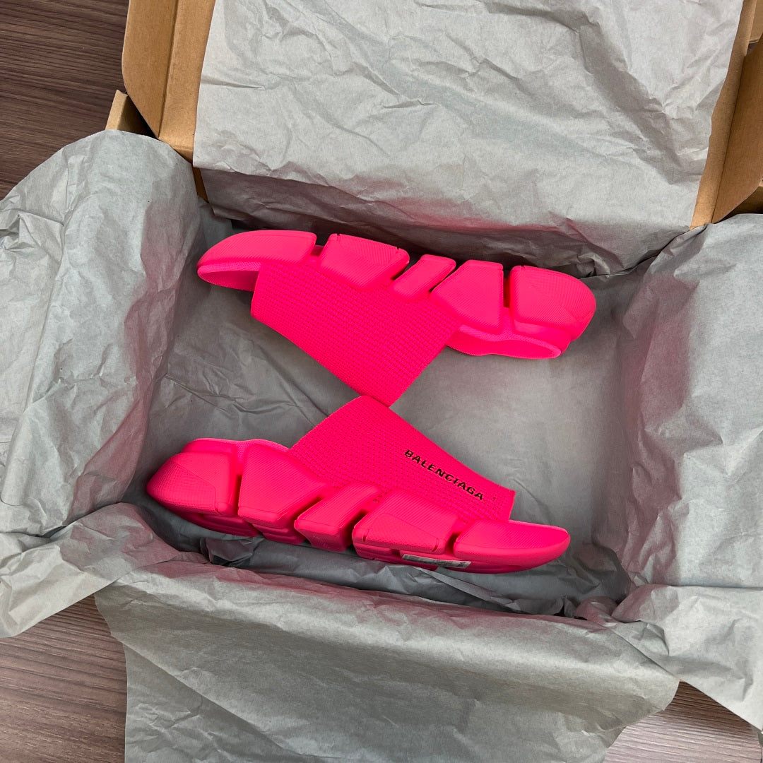Bright pink Balenciaga slide sandals inside tissue paper packaging, front pair