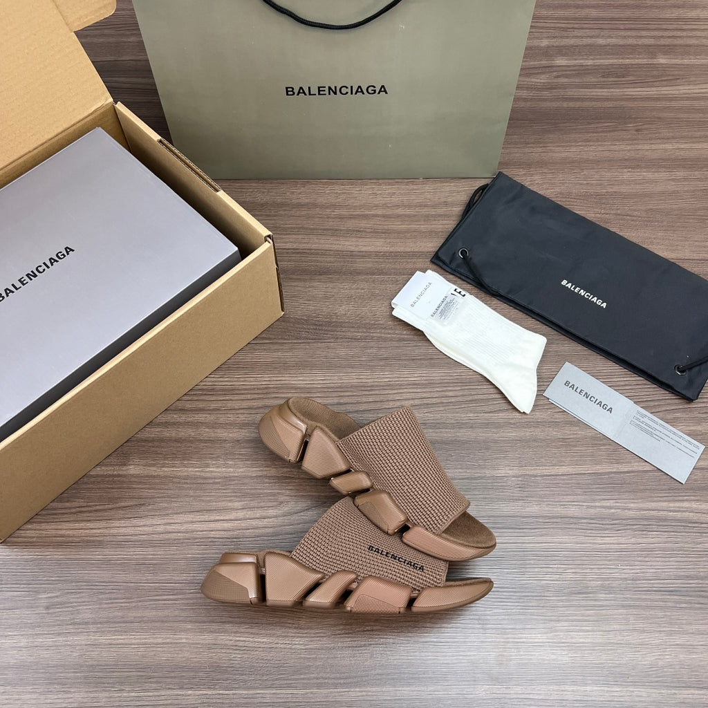 Tan knit slide sandals with cross straps and chunky rubber sole, angled view