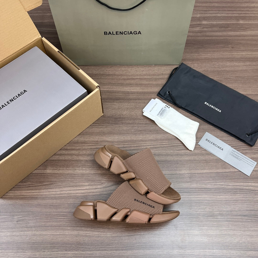 Tan knit slide sandals with cross straps and chunky rubber sole, angled view