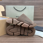 Tan knit slide sandals with thick treaded rubber sole and strap details