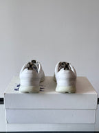 Pair of white low-top sneakers, back view with heel tabs on box
